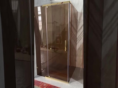 Elegante baño con vidrio tintado y marco de aluminio dorado